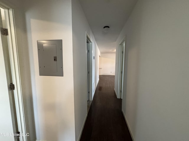 corridor with dark wood-type flooring and electric panel