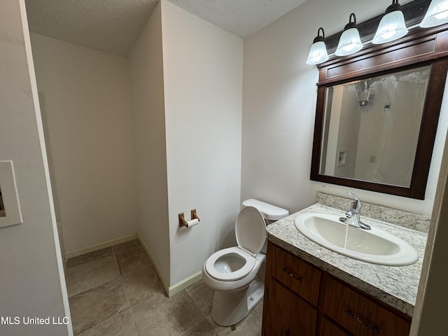 bathroom with vanity, tile patterned flooring, a textured ceiling, and toilet