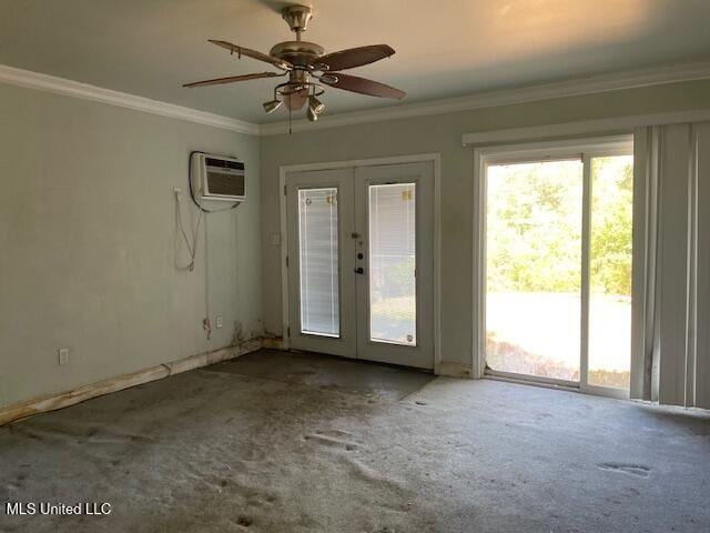 empty room with carpet flooring, crown molding, french doors, and a wall unit AC