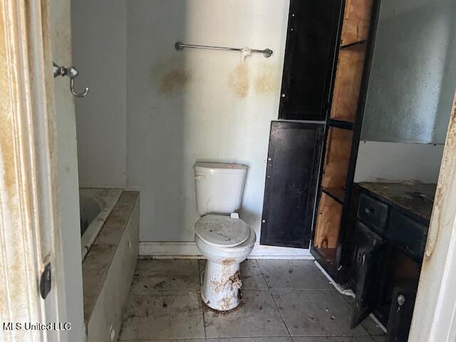 full bath featuring tile patterned flooring, toilet, and a tub