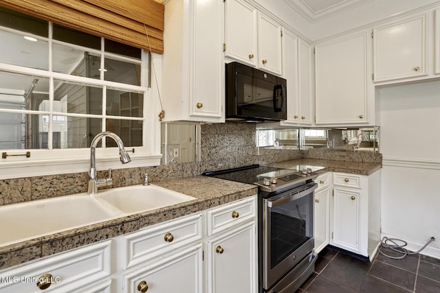 kitchen with dark tile patterned floors, a sink, stainless steel electric stove, white cabinets, and black microwave