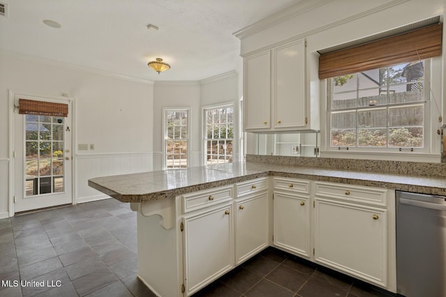 kitchen featuring a wainscoted wall, white cabinetry, a peninsula, dishwasher, and crown molding