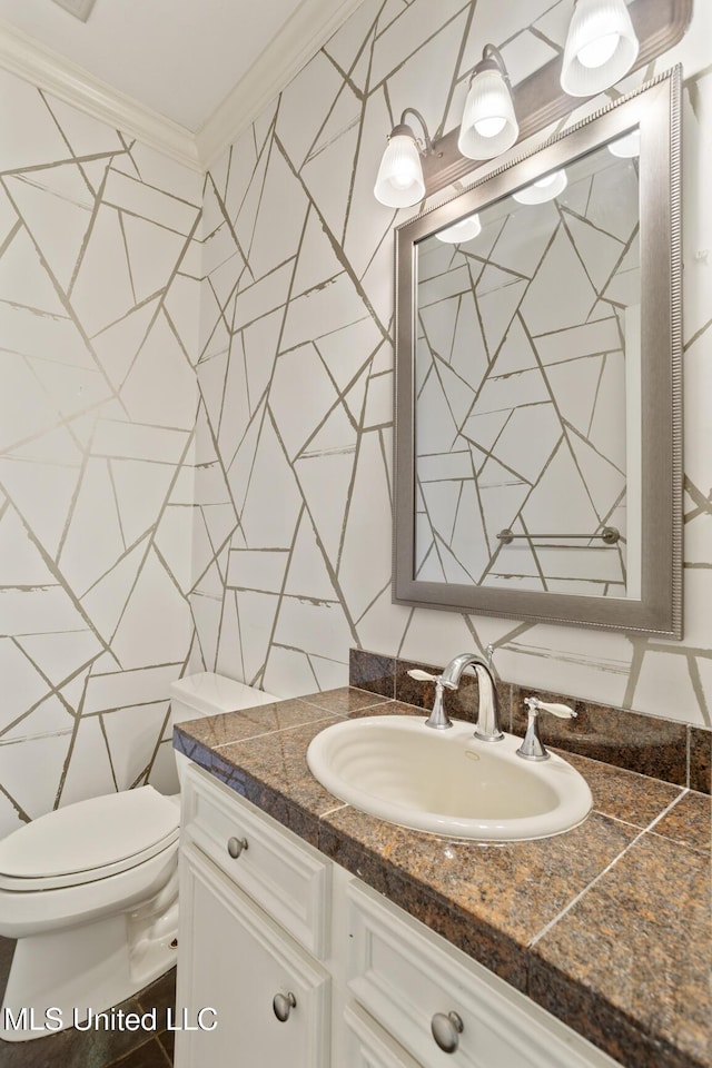 bathroom featuring toilet, tile walls, vanity, and ornamental molding