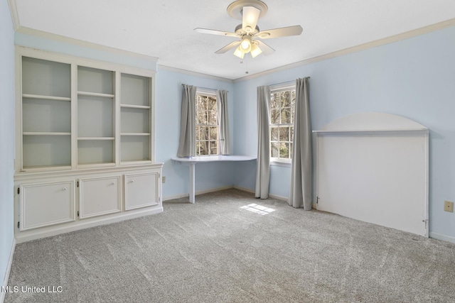 carpeted spare room featuring baseboards, ceiling fan, and ornamental molding