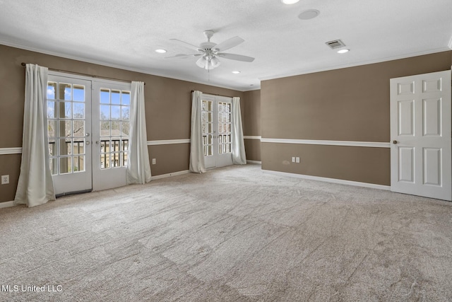 carpeted spare room featuring visible vents, ceiling fan, french doors, a textured ceiling, and crown molding