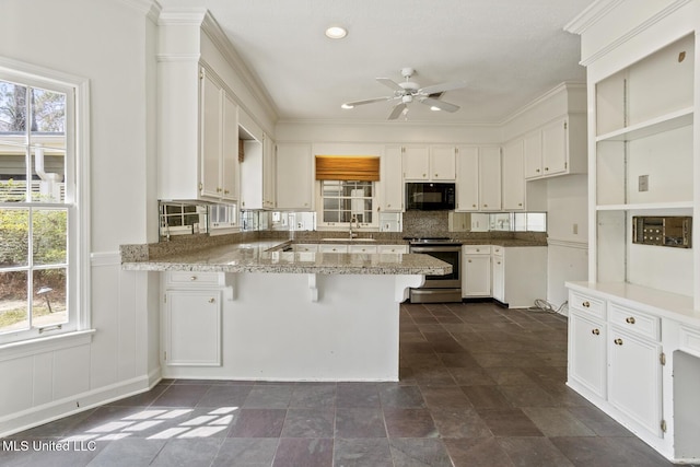 kitchen featuring a peninsula, ceiling fan, electric stove, black microwave, and tasteful backsplash