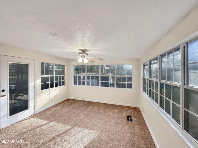 unfurnished sunroom with visible vents and ceiling fan