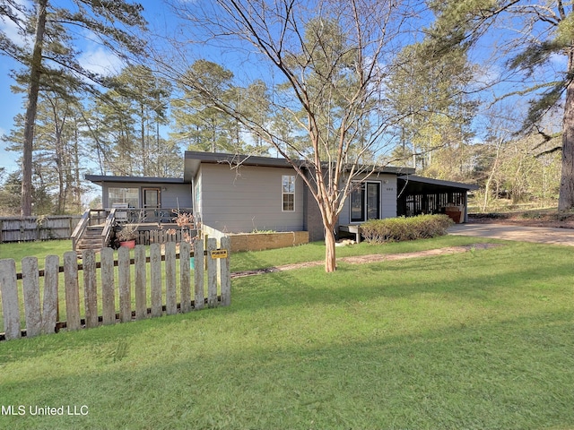 exterior space featuring a yard, a carport, driveway, and fence