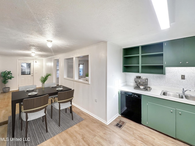 kitchen with light wood finished floors, visible vents, dishwasher, light countertops, and a sink