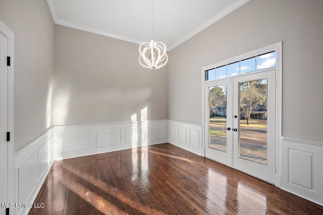 unfurnished dining area featuring ornamental molding, french doors, a notable chandelier, and dark hardwood / wood-style flooring