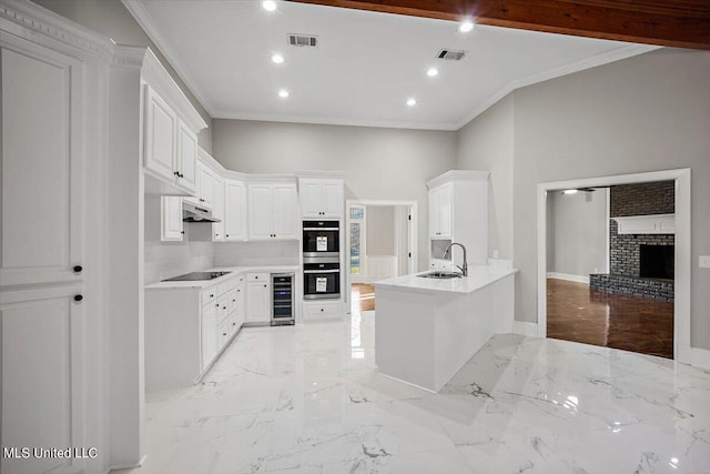 kitchen featuring wine cooler, stainless steel double oven, white cabinets, and kitchen peninsula