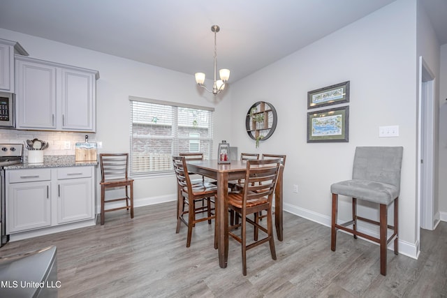 dining space featuring light hardwood / wood-style floors and a notable chandelier