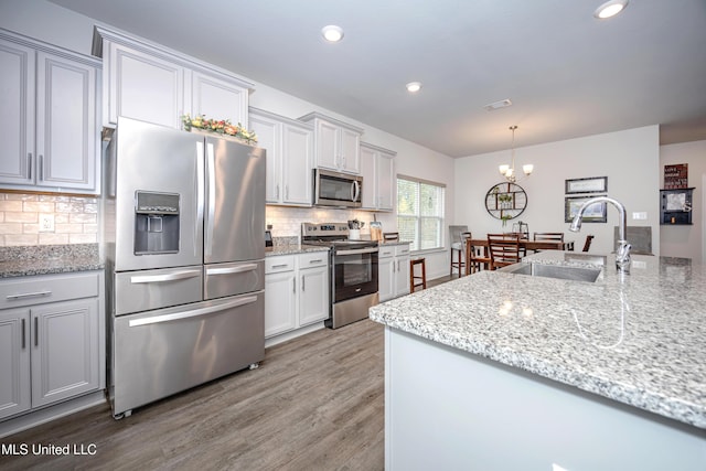 kitchen featuring decorative backsplash, sink, an inviting chandelier, and appliances with stainless steel finishes