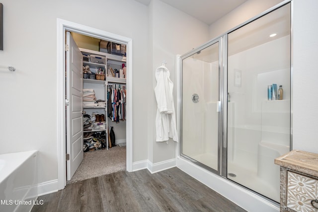 bathroom with hardwood / wood-style flooring and walk in shower