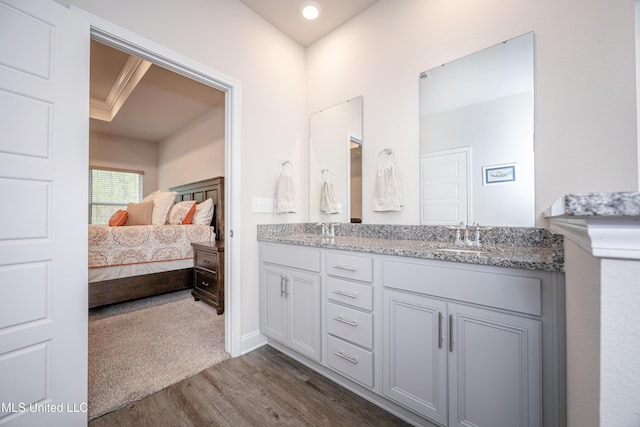 bathroom featuring hardwood / wood-style floors, vanity, and ornamental molding