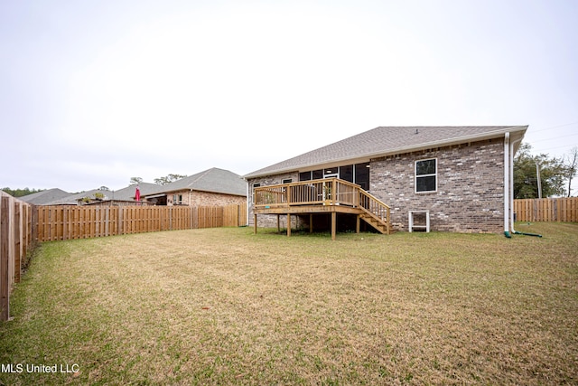 back of house featuring a lawn and a deck