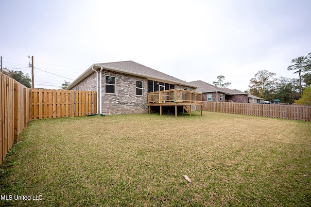 rear view of house with a deck and a yard