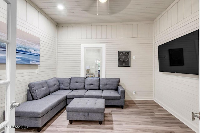 living room featuring wood ceiling, baseboards, and light wood finished floors