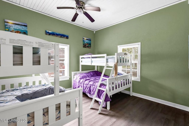 bedroom with crown molding, ceiling fan, wood finished floors, and baseboards