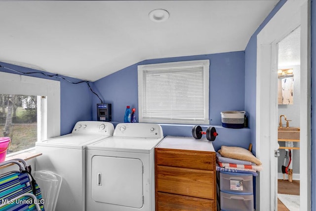 washroom with laundry area, washer and clothes dryer, and a sink