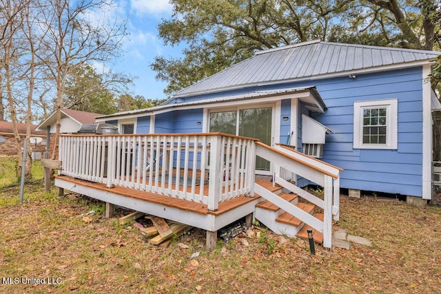 rear view of property featuring a deck and metal roof