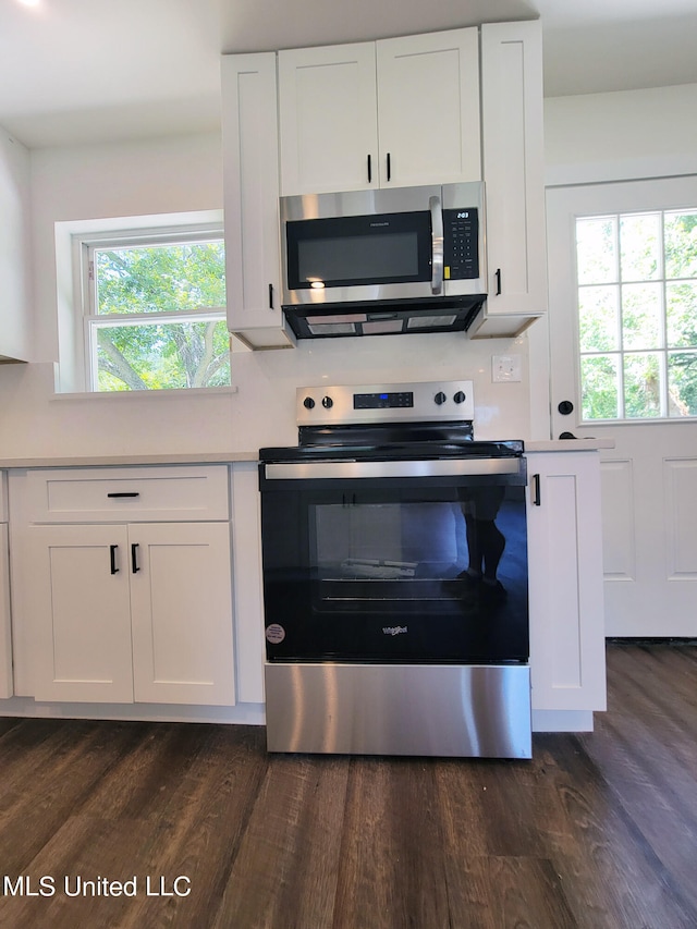 kitchen featuring a healthy amount of sunlight, appliances with stainless steel finishes, dark hardwood / wood-style floors, and white cabinetry