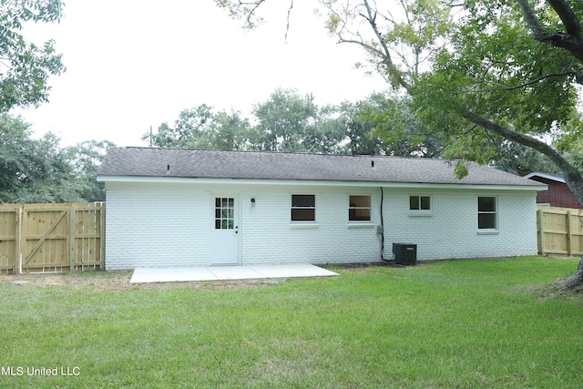 rear view of property with central air condition unit, a patio area, and a lawn