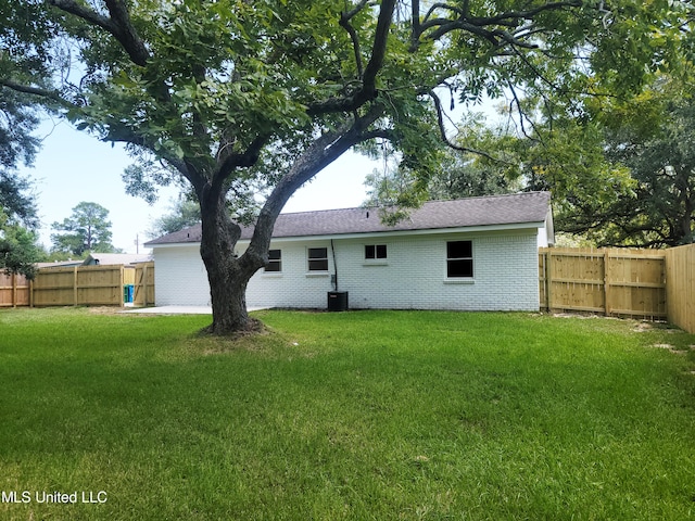 rear view of house featuring a yard