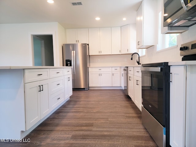 kitchen featuring white cabinetry, stainless steel appliances, and dark hardwood / wood-style floors