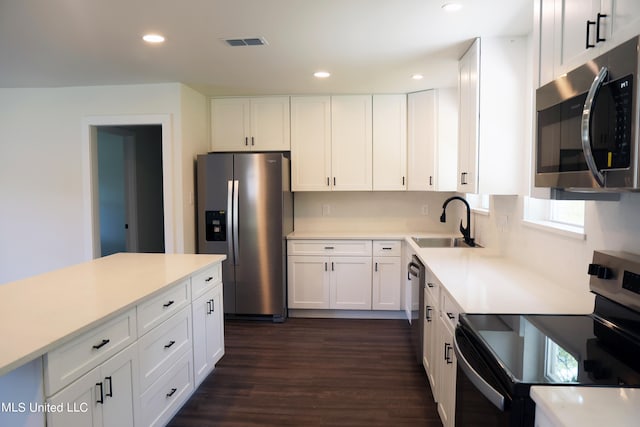 kitchen featuring sink, white cabinetry, stainless steel appliances, and dark hardwood / wood-style floors