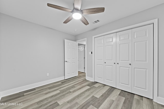 unfurnished bedroom featuring a closet, light hardwood / wood-style floors, and ceiling fan