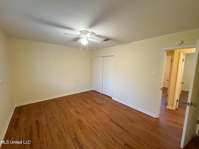 unfurnished bedroom with visible vents, baseboards, and wood finished floors