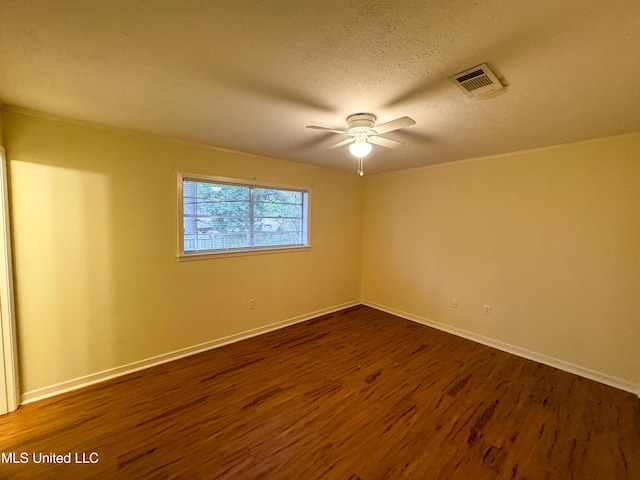 empty room with ceiling fan, visible vents, dark wood finished floors, and a textured ceiling