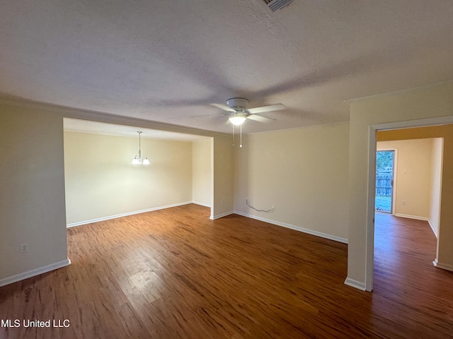 empty room featuring ceiling fan with notable chandelier, a textured ceiling, baseboards, and wood finished floors