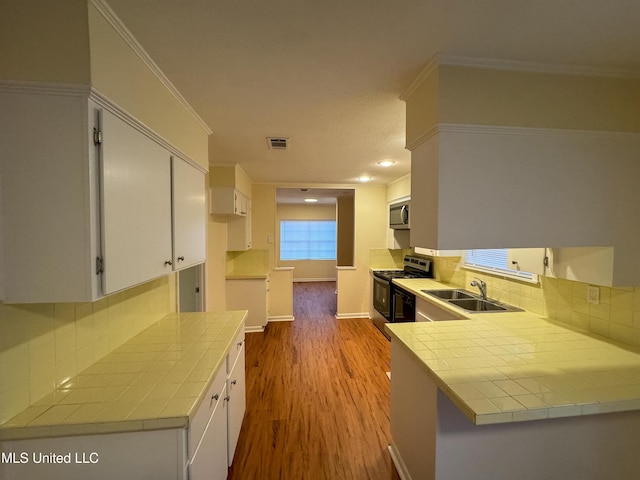 kitchen with tile countertops, stainless steel appliances, dark wood-style flooring, visible vents, and backsplash