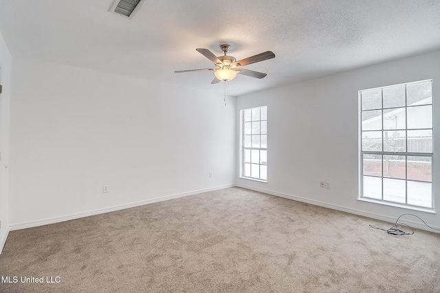 carpeted spare room with a textured ceiling and ceiling fan