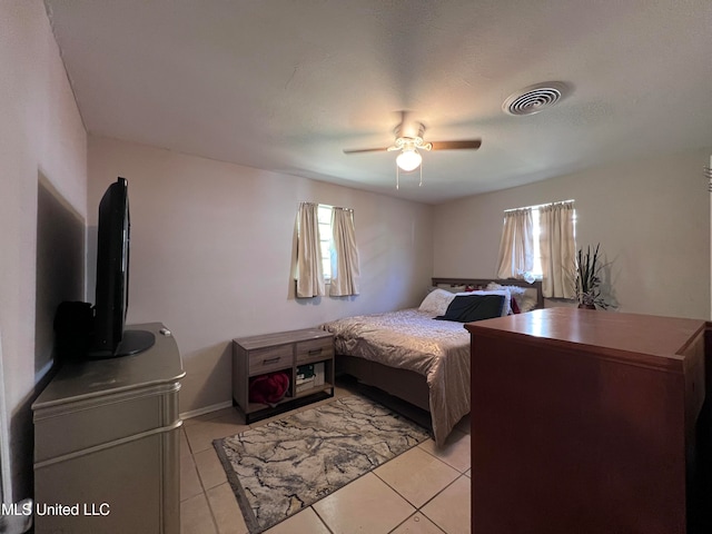 tiled bedroom featuring ceiling fan