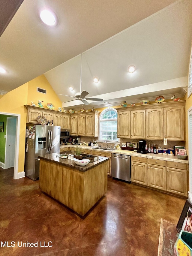 6520 Pleasant Grove Rd, Carthage, MS 39051 - kitchen with appliances with stainless steel finishes, ceiling fan, vaulted ceiling, a kitchen island, and tile counters