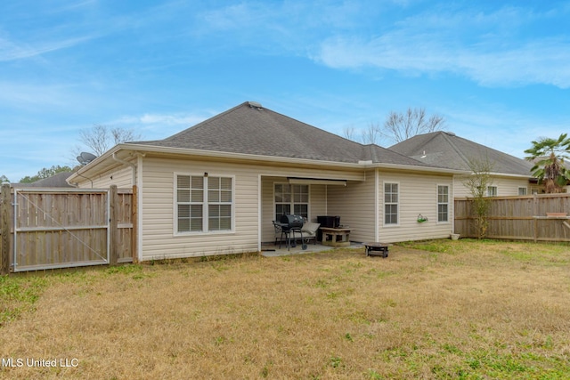 rear view of property featuring a lawn and a patio