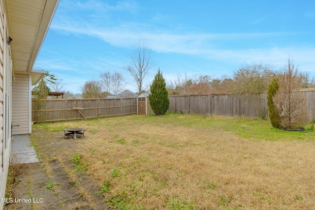 view of yard featuring a storage shed and a fire pit