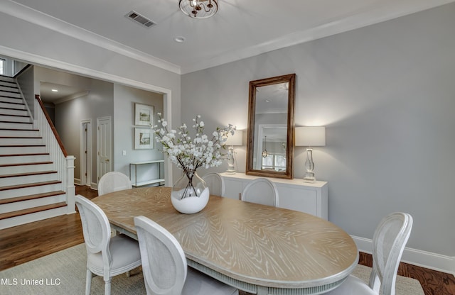dining area with wood finished floors, stairway, crown molding, and baseboards