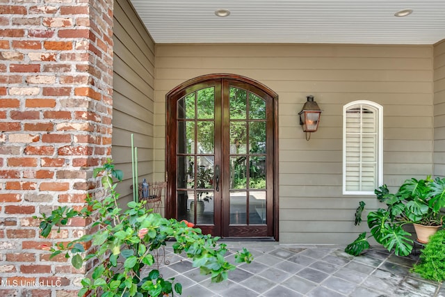 entrance to property featuring french doors and brick siding
