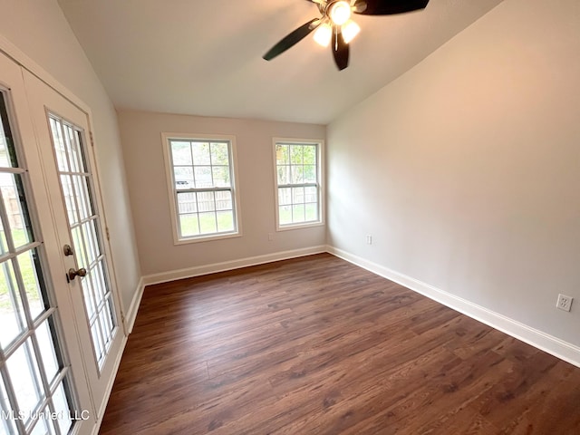 empty room with ceiling fan, french doors, dark hardwood / wood-style floors, and vaulted ceiling