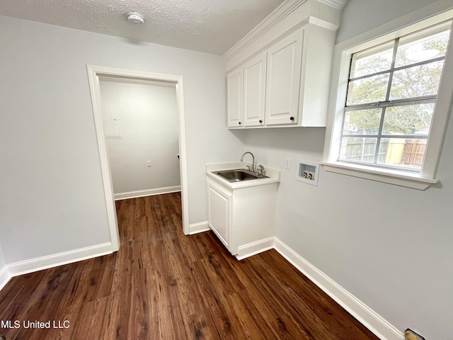 washroom with cabinets, hookup for a washing machine, a textured ceiling, dark wood-type flooring, and sink