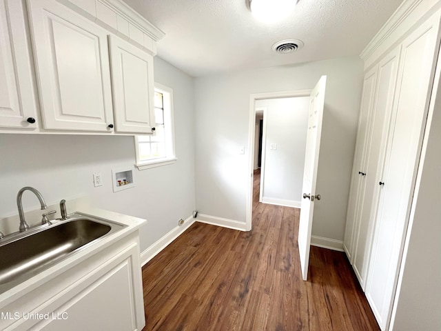 washroom featuring cabinets, washer hookup, a textured ceiling, dark wood-type flooring, and sink