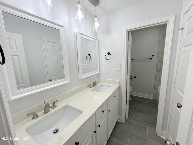 bathroom with tile patterned flooring, a textured ceiling, vanity, and toilet