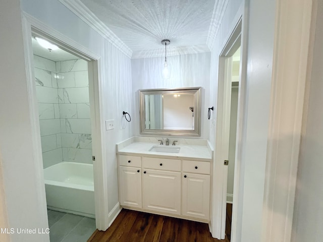 bathroom featuring hardwood / wood-style floors, vanity, ornamental molding, and tiled shower / bath