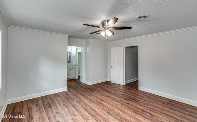 empty room with a textured ceiling, dark hardwood / wood-style floors, ceiling fan, and ornamental molding