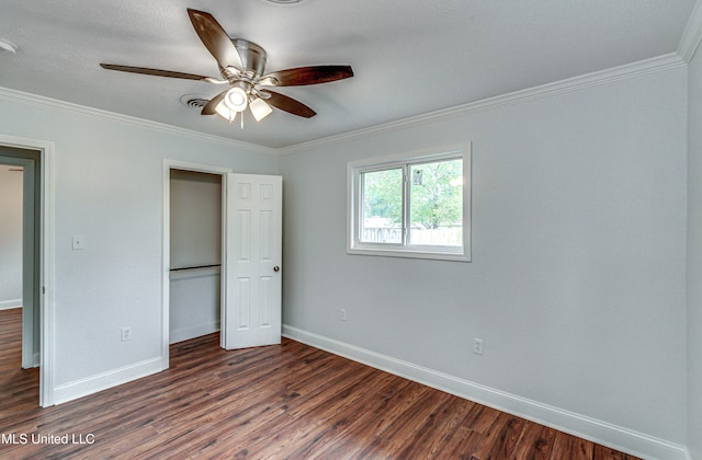 unfurnished bedroom featuring ceiling fan, crown molding, and dark wood-type flooring