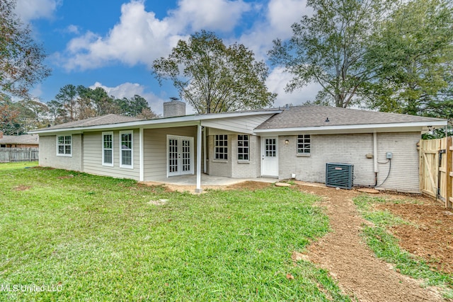 rear view of house featuring french doors, a patio, cooling unit, and a lawn